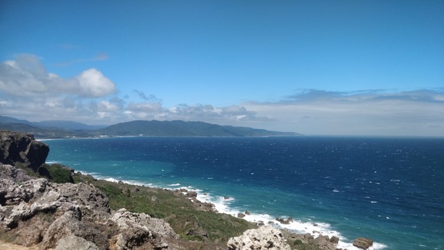 從山拍的東岸，海很藍藍的，後面有山，天氣好